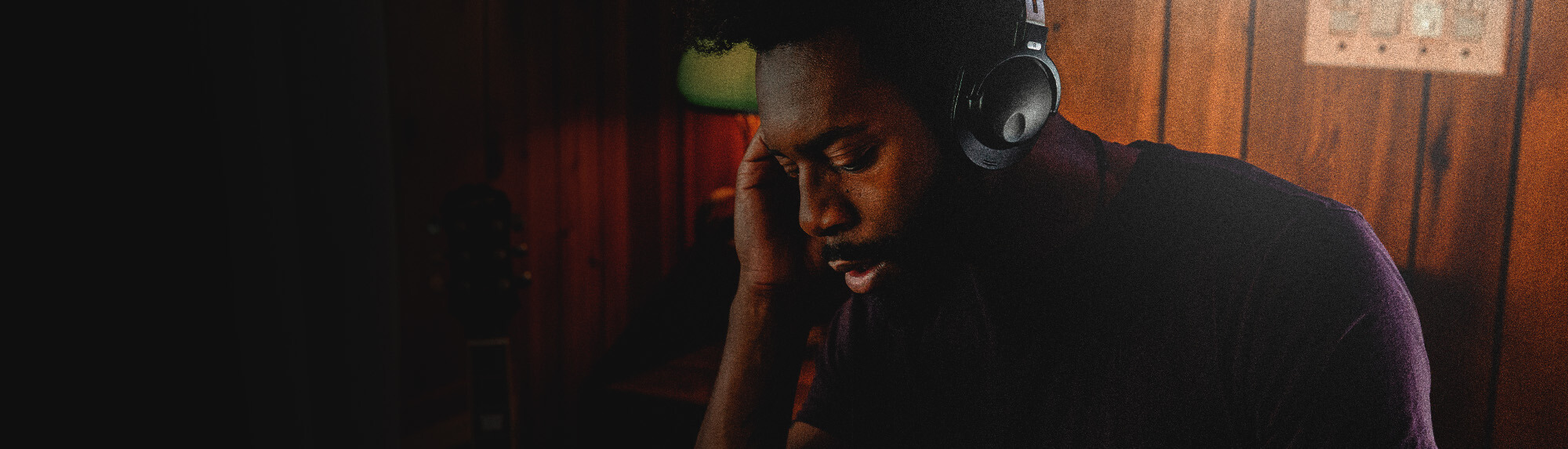 In the studio, a curly-haired DJ with a headset operates the mixer