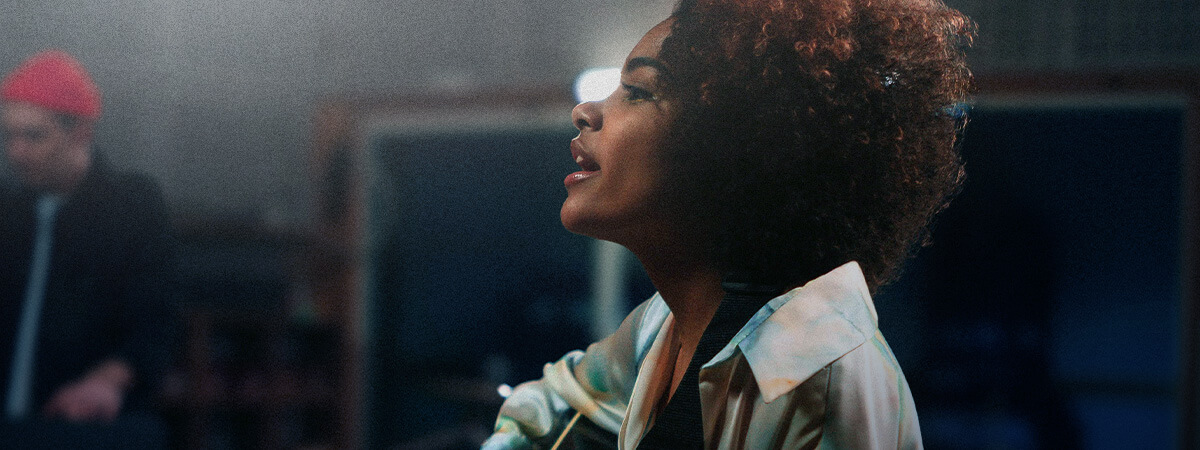 A woman recording singing and playing guitar